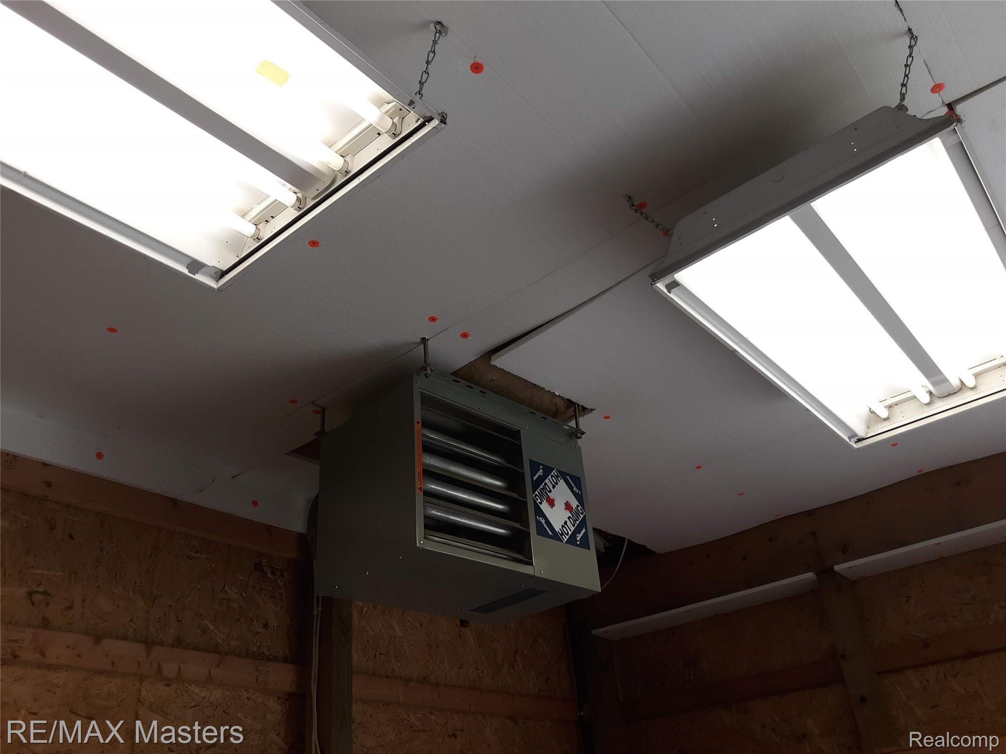 14550 Maxwell Road Carleton, MI 48117 - Photo 13 of 17 close up of wall furnace in outbuilding and lighting