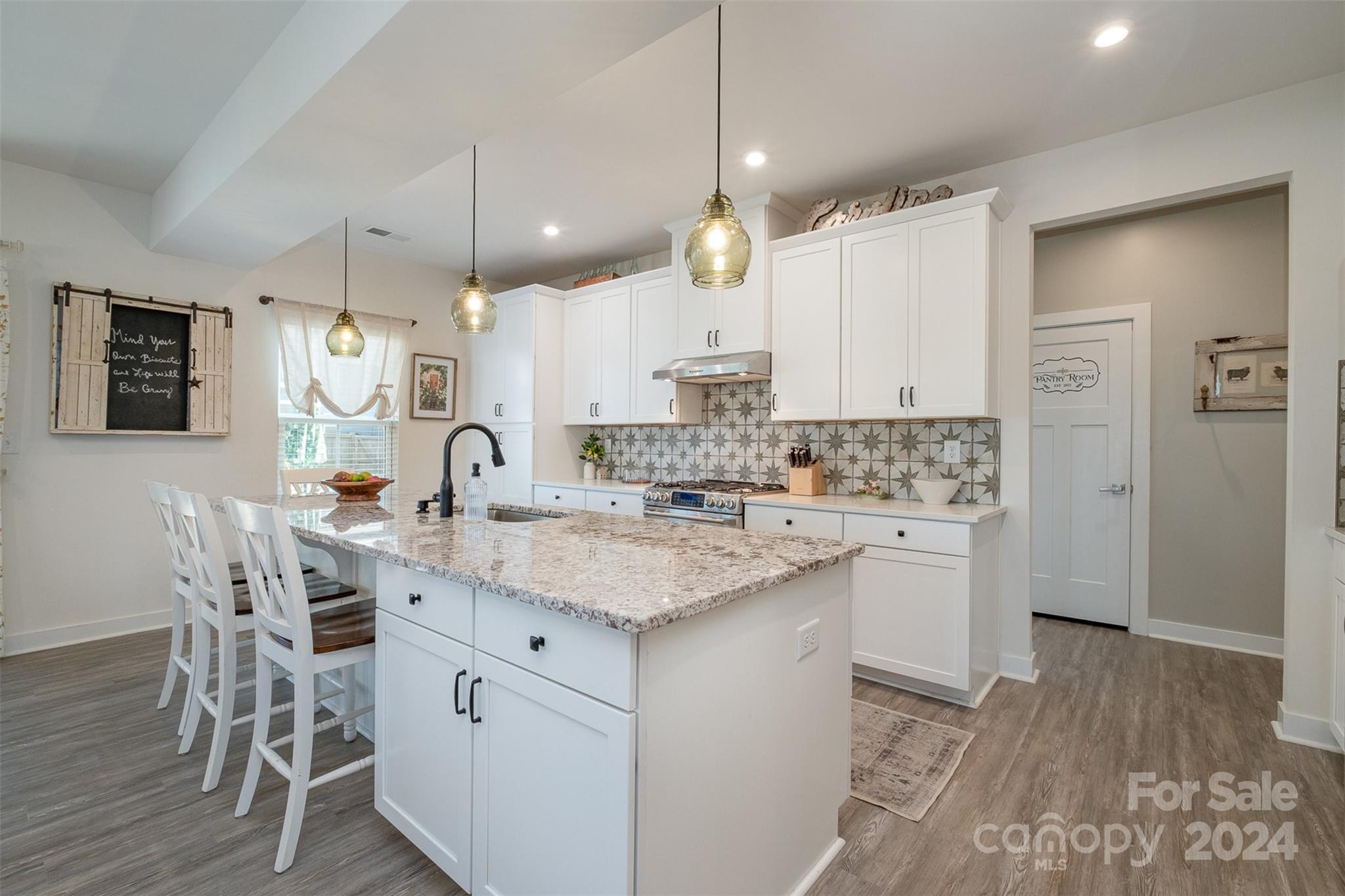 6202 Holland Street Fort Mill, SC 29707 - Photo 10 of 39 a kitchen with stainless steel appliances kitchen island granite countertop a sink cabinets and wooden floor