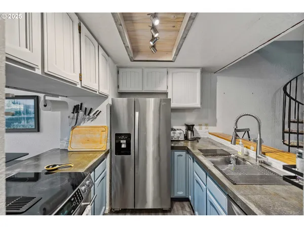 a kitchen with stainless steel appliances granite countertop a sink refrigerator and cabinets