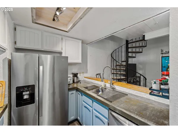 a kitchen with stainless steel appliances granite countertop a refrigerator and a sink