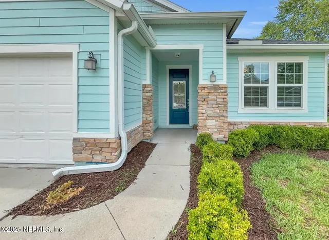a view of a brick house with plants