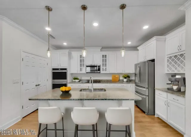 a kitchen with kitchen island a counter a refrigerator and a sink