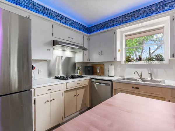 a kitchen with white cabinets and white appliances