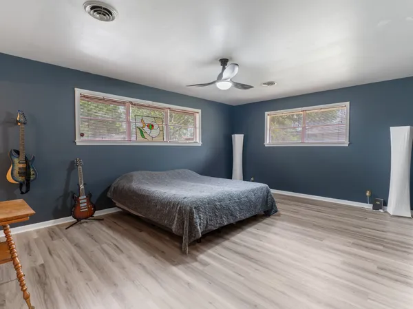 a bedroom with a bed and wooden floor