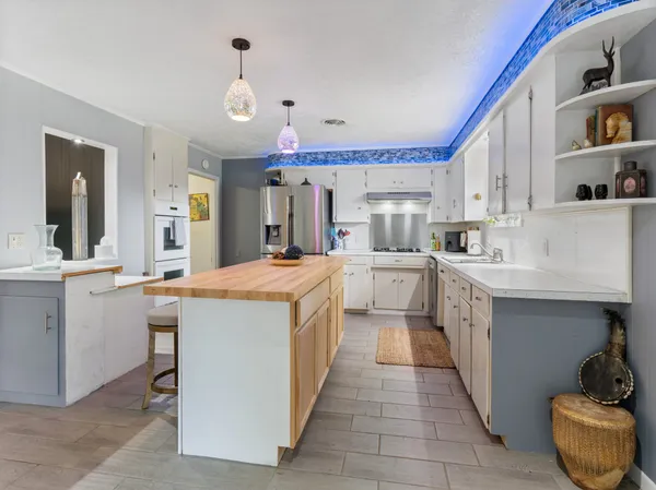 a large kitchen with stainless steel appliances kitchen island granite countertop a sink and cabinets