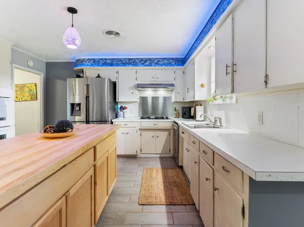 a kitchen with stainless steel appliances sink stove and cabinets