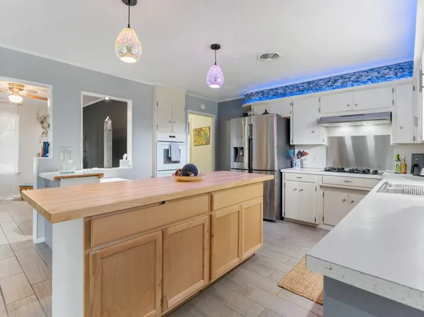 a kitchen with white cabinets sink and stove