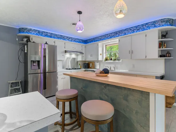 a kitchen with stainless steel appliances granite countertop a sink refrigerator and microwave
