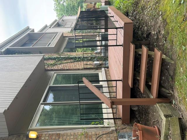 629 Oakbrook West, Unit 18 Rochester, MI 48307 - Photo 8 of 18 Expansive exterior deck with dark wood-finish planking, black metal balusters, and a solid wood handrail