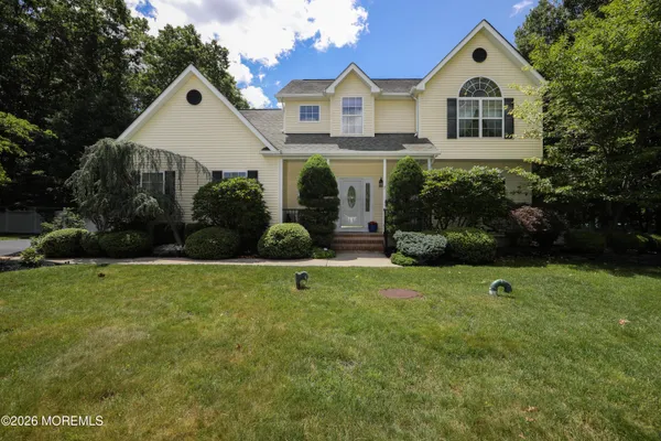 a view of house with garden and tall trees