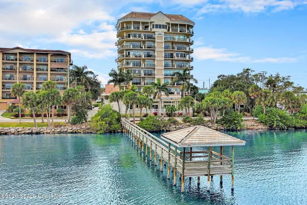 a front view of multi story residential apartment building with yard and sign board
