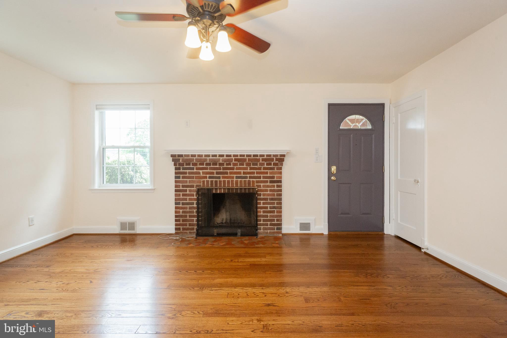 2016 Lansdowne Way Silver Spring, MD 20910 - Photo 4 of 23 an empty room with wooden floor fireplace and windows