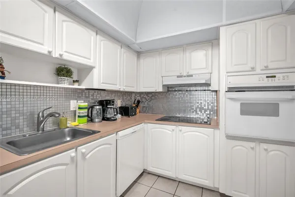 a kitchen with white cabinets and white appliances