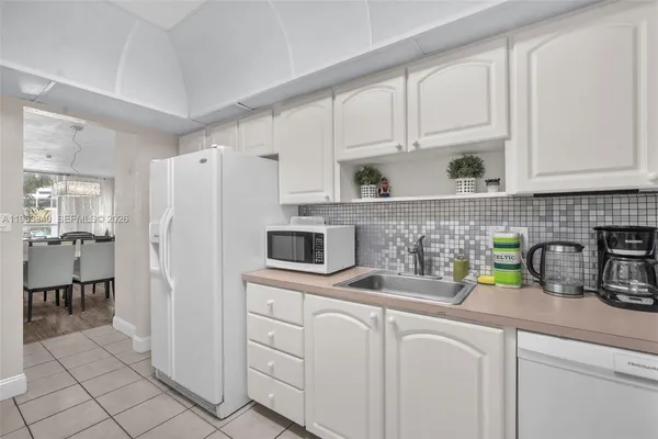 a kitchen with appliances a sink and cabinets