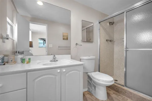 a bathroom with a granite countertop sink toilet and shower