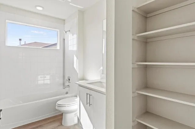 an empty room with closet and a ceiling fan