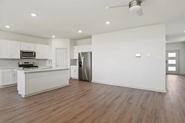 a view of kitchen with stainless steel appliances refrigerator stove microwave and cabinets