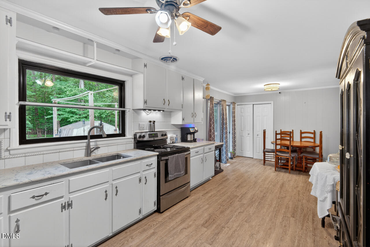 1420 Goodwin Road Durham, NC 27712 - Photo 21 of 54 a kitchen with kitchen island granite countertop a stove top oven a sink a counter space and cabinets