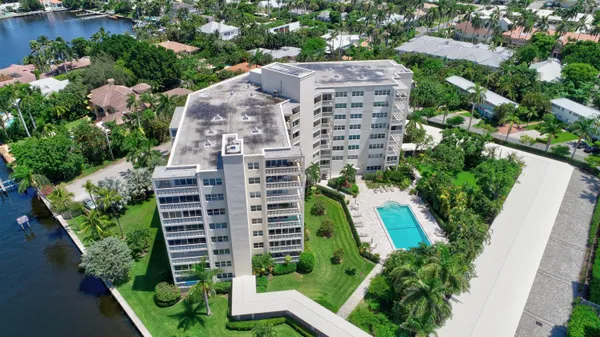 an aerial view of a multi story residential apartment building with a yard