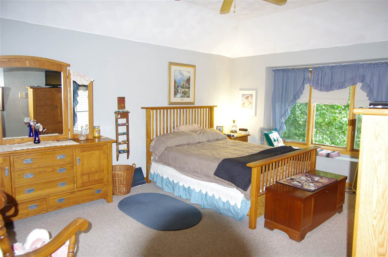 8407 North Kilbuck Road Monroe Center, IL 61052 - Photo 13 of 20 a bed sitting in a bedroom next to a window