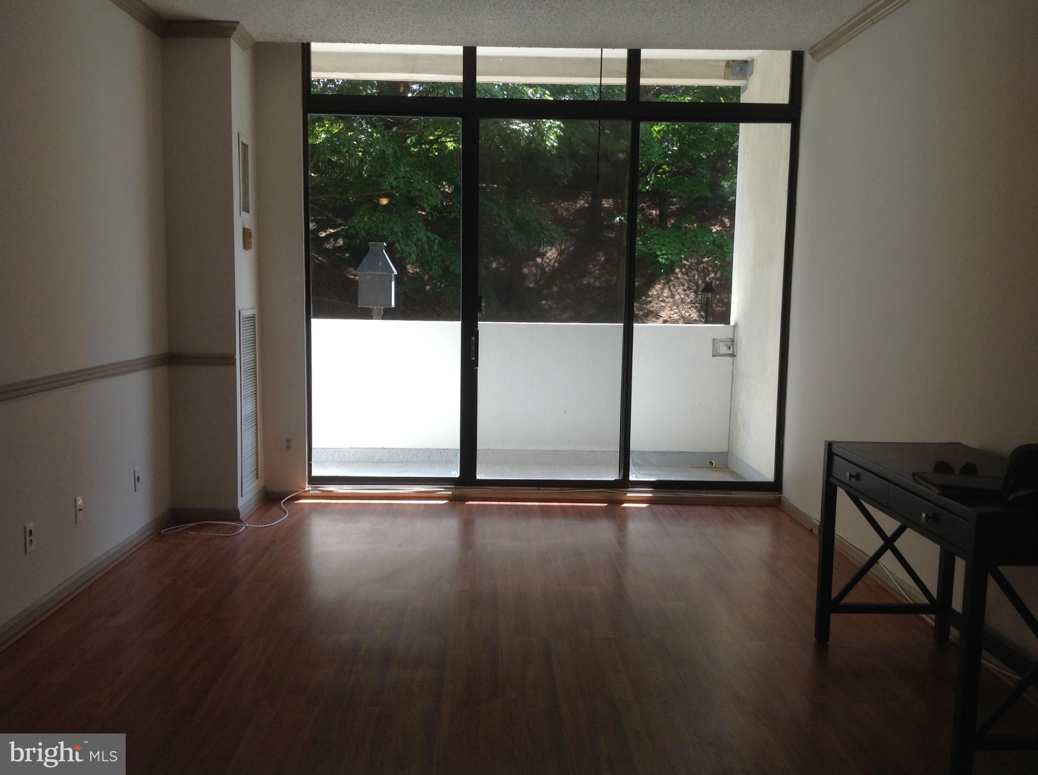 5911 Edsall Road, Unit 107 Alexandria, VA 22304 - Photo 5 of 11 an empty room with wooden floor and windows