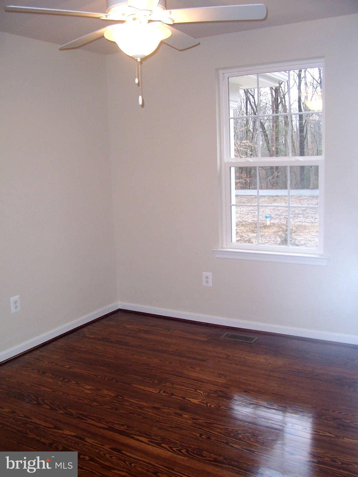 361 Emerson Road Owings, MD 20736 - Photo 16 of 25 an empty room with wooden floor and windows