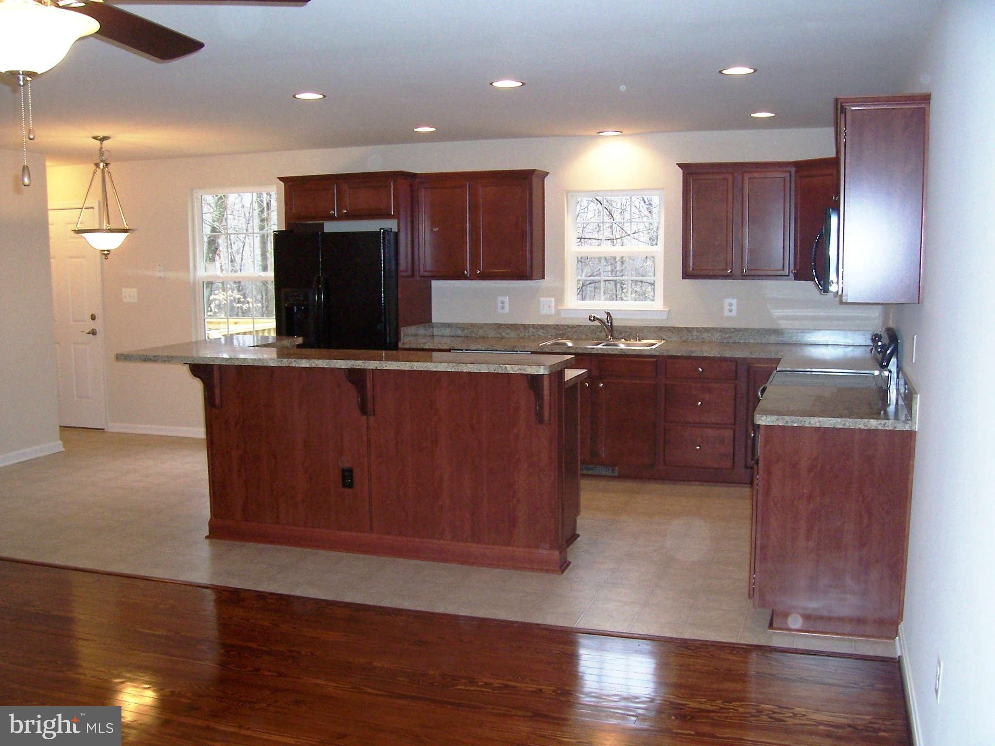 361 Emerson Road Owings, MD 20736 - Photo 6 of 25 a kitchen with stainless steel appliances granite countertop wooden cabinets a stove a sink and a island