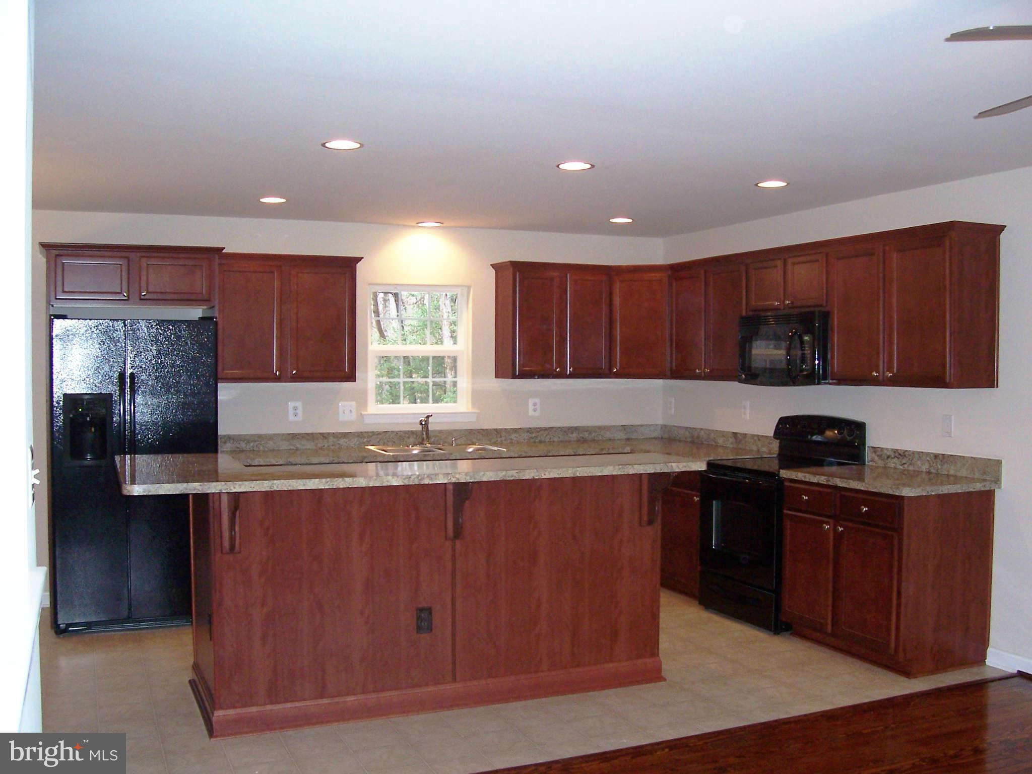 361 Emerson Road Owings, MD 20736 - Photo 8 of 25 a kitchen with kitchen island granite countertop wooden cabinets stainless steel appliances a sink and a counter top