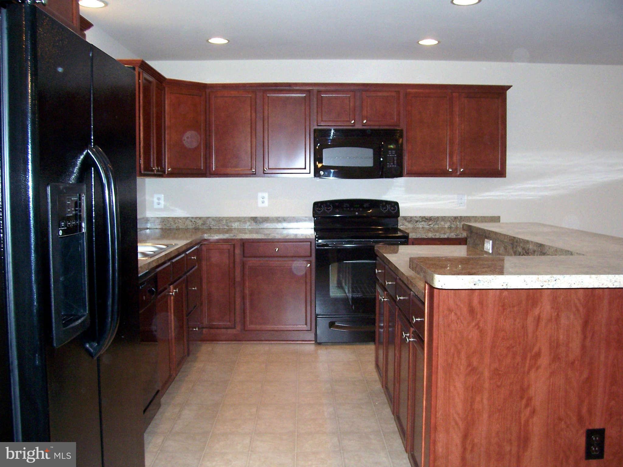 361 Emerson Road Owings, MD 20736 - Photo 9 of 25 a kitchen with stainless steel appliances granite countertop a stove a sink dishwasher and a refrigerator