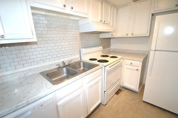 a kitchen with white cabinets and white appliances