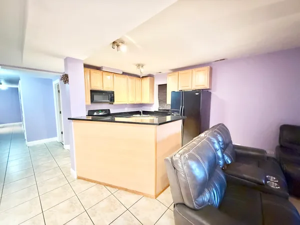 a kitchen with stainless steel appliances granite countertop a refrigerator a stove a sink dishwasher and microwave oven