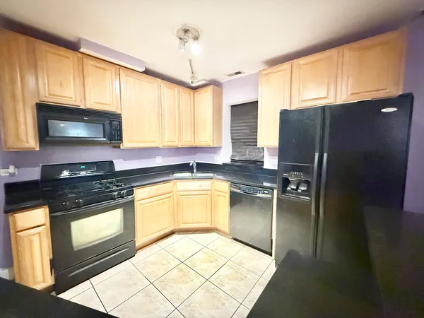 a kitchen with stainless steel appliances granite countertop a sink a refrigerator and a stove