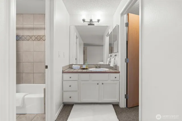 a bathroom with a double vanity sink mirror and bathtub