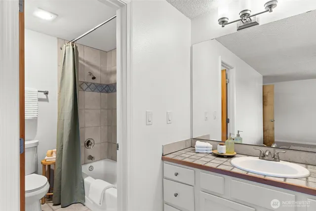 a bathroom with a granite countertop sink double mirror and a shower