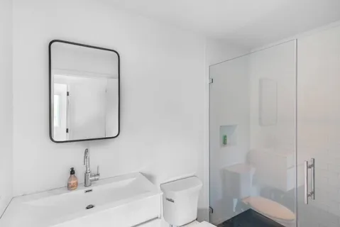 a bathroom with a sink a toilet and shower