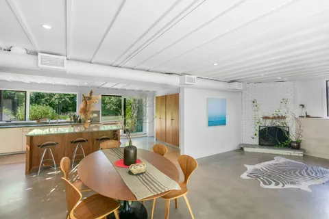 a living room with furniture kitchen view and a large window
