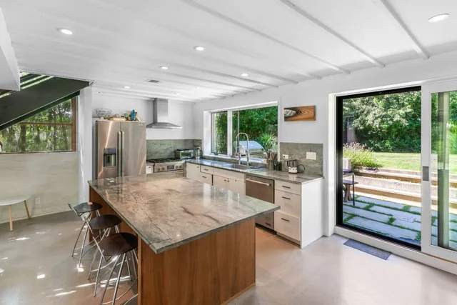 a kitchen with stainless steel appliances granite countertop a stove refrigerator and cabinets