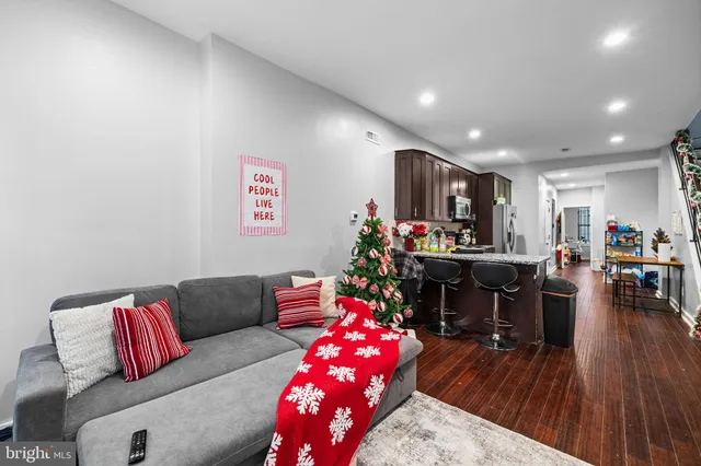 a living room with furniture and a wooden floor