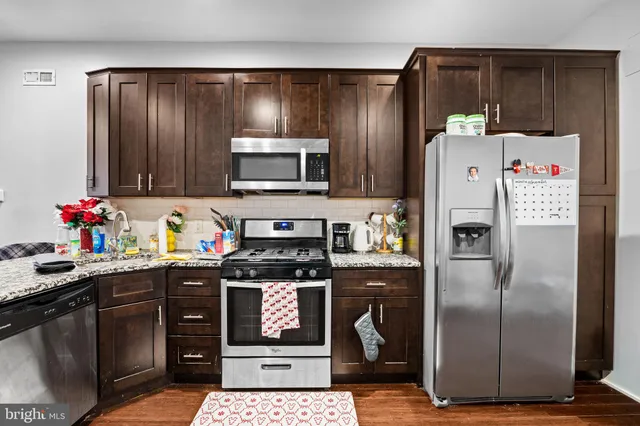 a kitchen with stainless steel appliances granite countertop a refrigerator sink and stove