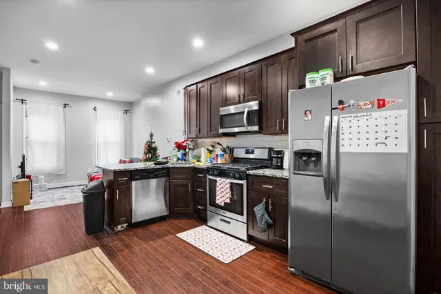 a kitchen with stainless steel appliances a refrigerator and a stove top oven