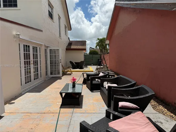 a view of a patio with table and chairs and potted plants