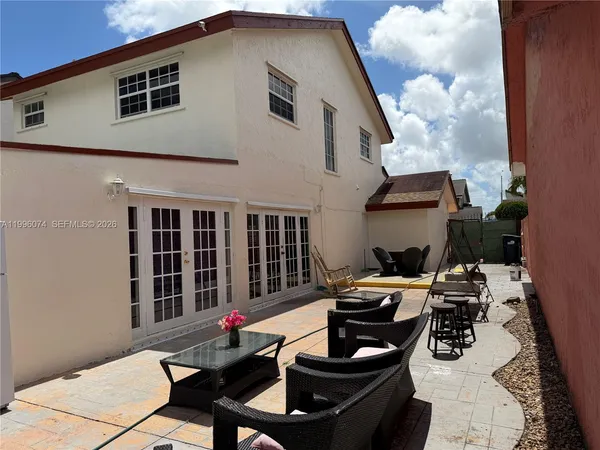a view of a patio with table and chairs and potted plants