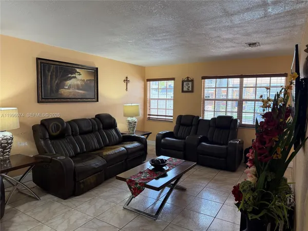 a living room with furniture and a potted plant