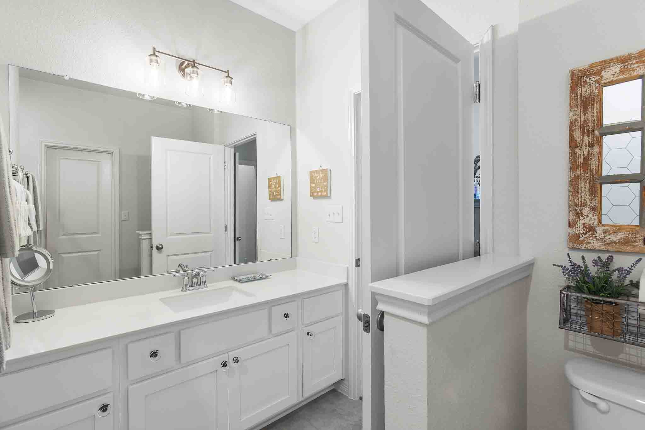 166 West Branch Road Kyle, TX 78640 - Photo 34 of 39 A well-lit primary bathroom vanity provides ample counter space and storage.