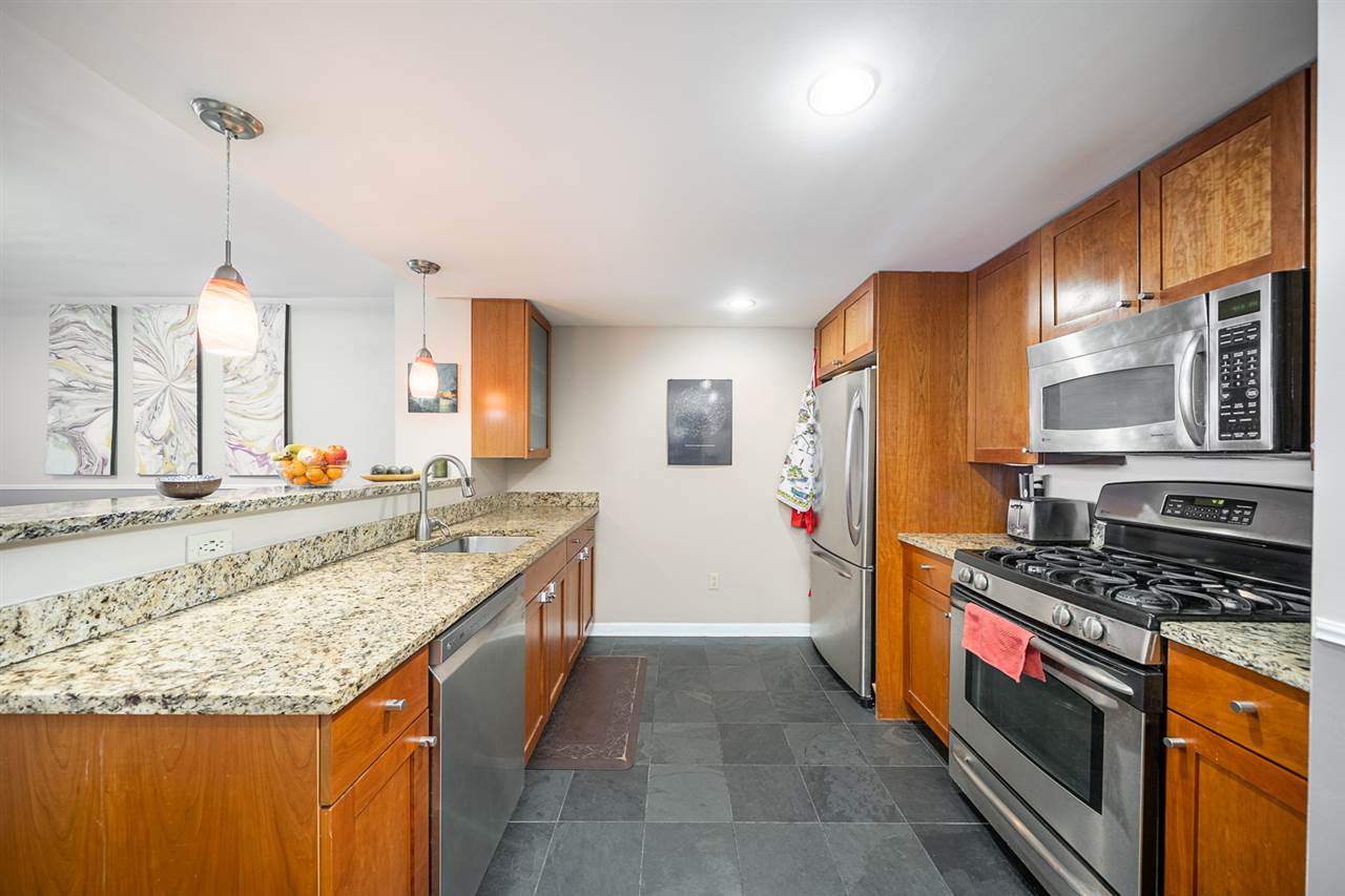 700 Grove Street, Unit 4V Jersey City, NJ 07310 - Photo 2 of 25 a kitchen with stainless steel appliances granite countertop a stove and a sink