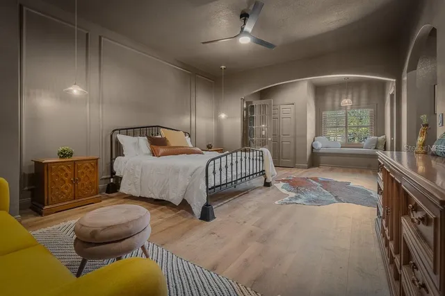 a bedroom with a bed mirror and window