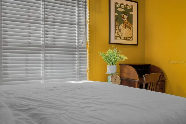 a bedroom with a bed and painting on the wall
