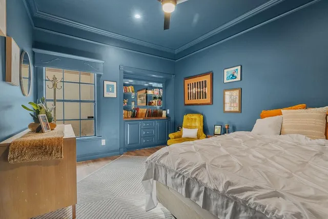 a bedroom with a bed and a dresser next to a window