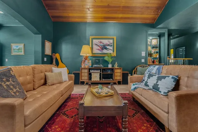 a living room with furniture a rug and a wall painting