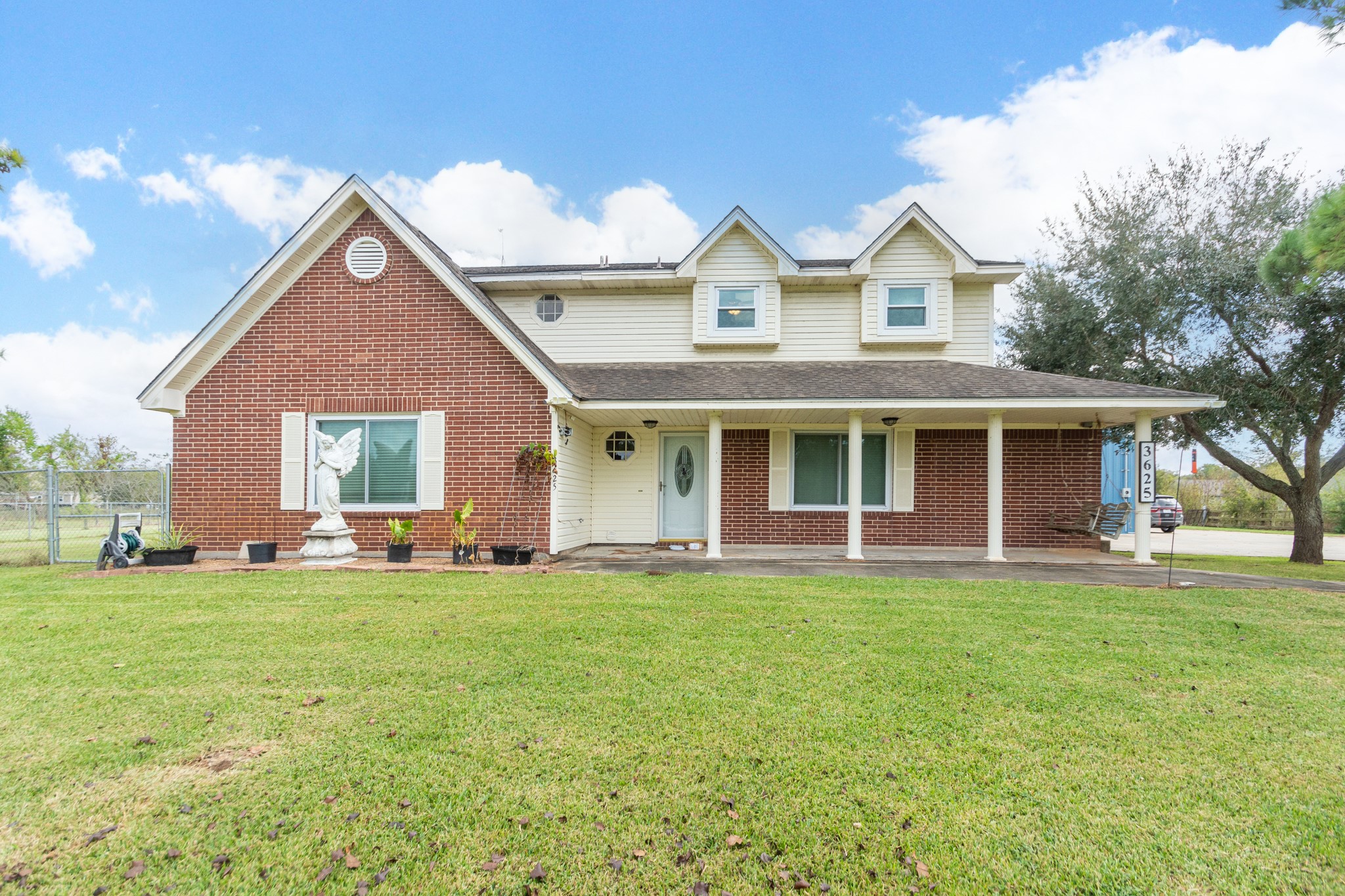 a front view of a house with a garden and trees